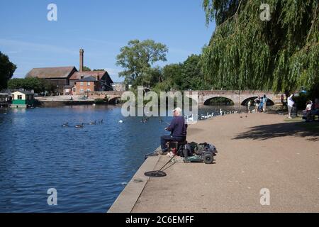 A man fishing in The River Avon in Stratford upon Avon in Warwickshire in the UK taken on the 22nd June 2020 Stock Photo