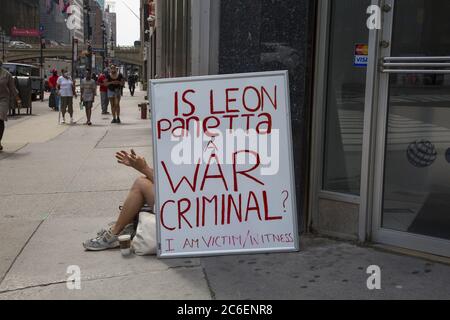 Man with a sign questioning if Leon Panetta is a war criminal. He was head of the CIA & Secretary of Defense as well as holding other US Government positions.