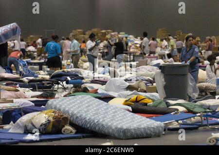 Austin, Texas September 3, 2005: Refugees from Hurricane Katrina continue to pour into Texas shelters including the Austin Convention Center, which is expecting over 5,000 people in the next three days. Cots and other bedding fill the center's floor as a maintenance worker tries to keep the space clean. ©Bob Daemmrich Stock Photo