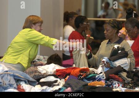 Austin, Texas September 4, 2005: Hurricane Katrina refugees pick through donated clothing at the Austin Convention Center site which is housing 4,000 displaced people, mostly from the New Orleans area. Many evacuees fled from their homes with few possessions. ©Bob Daemmrich Stock Photo