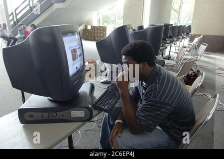 Austin, Texas September 4, 2005:  A Hurricane Katrina evacuee from Metairie, LA sits at a bank of computers to look at a news clip on the internet at the Austin Convention Center refugee center where 4,000 people have been sent.  ©Bob Daemmrich Stock Photo