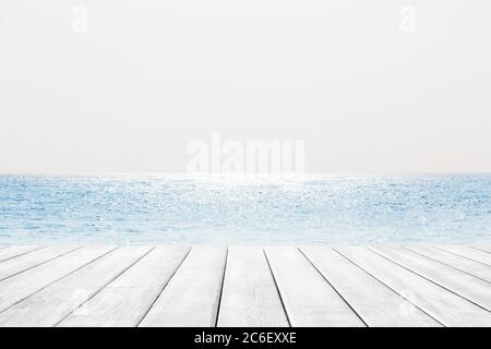 Blurred blue sky and sea with bokeh light and white wooden table background. Stock Photo