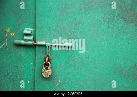 lock hangs on bright green garage door. Locked datasecret information concept Stock Photo