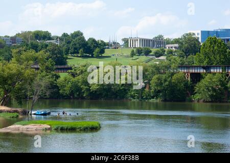 RICHMOND, VIRGINIA - August 8, 2019: a view of the Virginia War Memorial over the James River; Rafters swim in the foreground Stock Photo