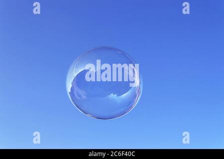 large round soap bubble floating in the blue sky in daylight Stock Photo