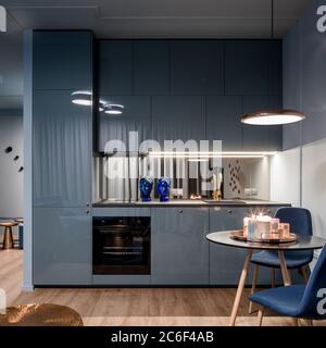 Small and elegant kitchen interior in blue with dining area Stock Photo