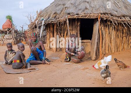 Black women with children of the Hamar / Hamer tribe in front of hut in village Turmi, Omo River valley, Debub Omo Zone, Southern Ethiopia, Africa Stock Photo