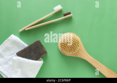 environmentally friendly toothbrushes and body brushes with soap and towel on green background zero waste Stock Photo