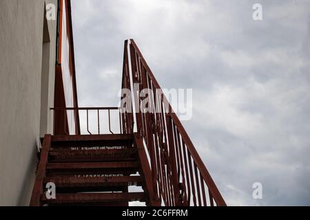 Metal staircase to roof of building on gloomy sky Stock Photo