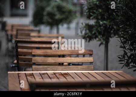 empty chairs and tables with rain drops in front of a restaurant during corona lockdown Stock Photo