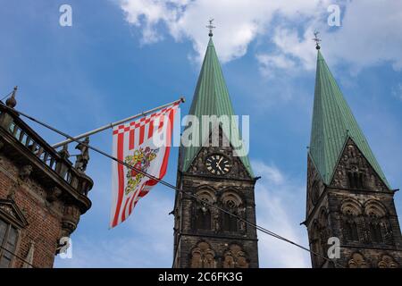 Detail of the historic unesco world heritage town hall of bremen, germany with the flag of Bremen and the towers of the St. Petri Dom in background