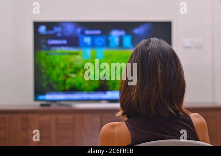 Women watching tv shows and use remote controller Stock Photo
