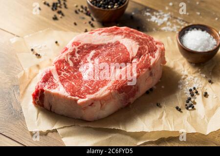 Raw Grass Fed Ribeye Steak with Salt and Pepper Stock Photo