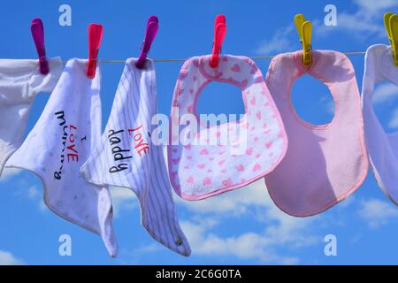 Baby bibs on a washing line on a sunny day Stock Photo