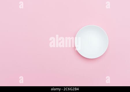 Empty white ceramic round plate isolated on pink Stock Photo
