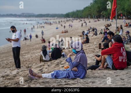 Badung, Bali, Indonesia. 9th July, 2020. People flock to the world famous Kuta Beach as the local government begins to reopen beaches for Balinese citizens as a stage of ''new normal'' plan. Kuta Beach has been closed since March 30, 2020 due to Covid-19 coronavirus concern. Credit: Dicky Bisinglasi/ZUMA Wire/Alamy Live News Stock Photo