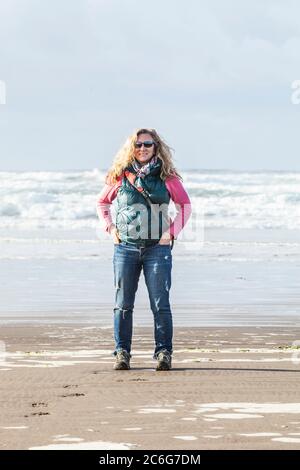 A woman standing on a beach. Pacific coast, Seaside, Oregon, USA.