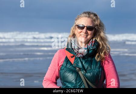A woman standing on a beach. Pacific coast, Seaside, Oregon, USA.