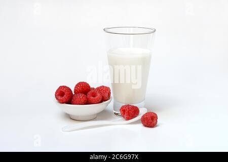 Raspberries in bowl and glass of milk, Germany Stock Photo