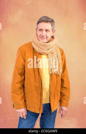 Attractive elderly man elegantly dressed in sweater jacket and scarf Stock Photo