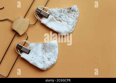 White color of lace reusable face masks hanging on clothes hanger . Sewing cloth mask to prevent the outbreak of Covid-19 virus and dust pollution. Stock Photo