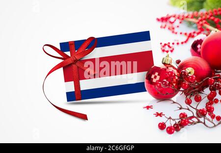 Costa Rica flag on new year invitation card with red christmas ornaments concept. National happy new year composition. Stock Photo
