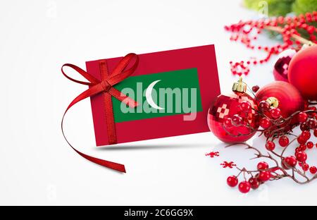 Maldives flag on new year invitation card with red christmas ornaments concept. National happy new year composition. Stock Photo