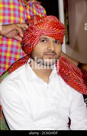 Asian man wearing turban with traditional style in indian hindu culture, Indian groom in colorful dress, selective focus with blur.