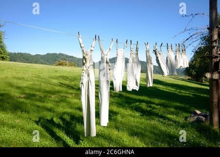 A clothespin hangs on the washing line. A rope with clean linen and clothes  outdoors on the day of the laundry. Against the background of green nature  Stock Photo - Alamy