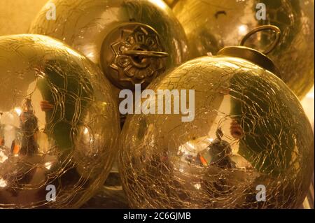 Bright, shiny, golden-colored metallic balls or Christmas decorations are viewed in close-up.and grouped close together.  Stock Photo