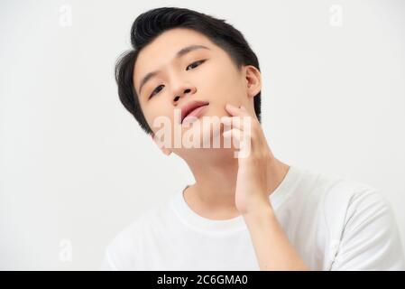 health and beauty concept - beautiful calm man touching his face Stock Photo