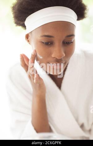 Mixed race woman spending time at home self isolating and social distancing in quarantine lockdown during coronavirus covid 19 epidemic, taking care o Stock Photo