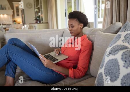 Woman using laptop while sitting on the couch Stock Photo