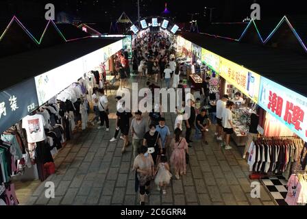 An aerial view of tourists wandering among and buying food from snack bars at Xingshun International Night Market, Asia's largest night market, Shenya Stock Photo