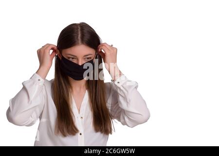 A young woman wears a black protective mask. Isolated on white. The concept of a viral epidemic. avoiding covid-19 . Stock Photo