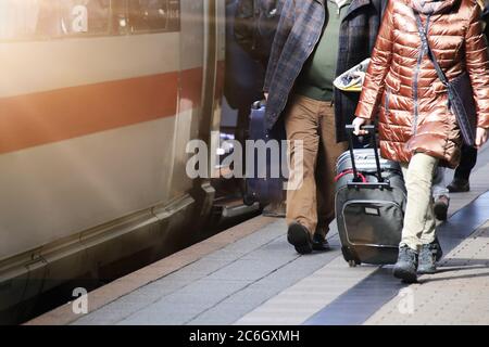 Long distance train at the station with passengers getting on and off Stock Photo