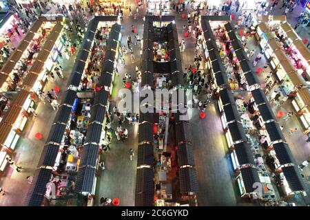 An aerial view of tourists wandering among and buying food from snack bars at Xingshun International Night Market, Asia's largest night market, Shenya Stock Photo