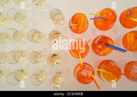 Lots of wine glasses and orange Aperol Spritz cocktails with orange slices and tubes. Stock Photo