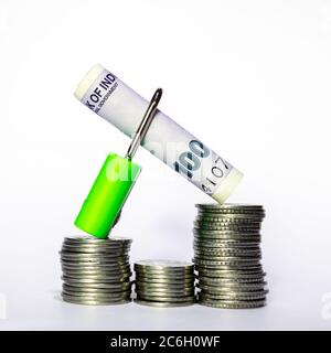 Indian coins on white background. Close-up view. Coins are located above the center of frame. Currency note in a lock. A conceptual image. Stock Photo