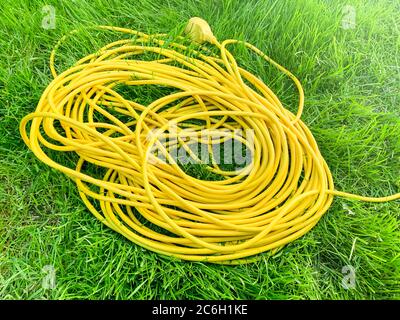 Yellow electric cable on green grass. Photo Stock Photo