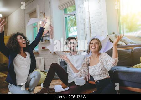 Two girls having fun and smiling guy looking at one Stock Photo
