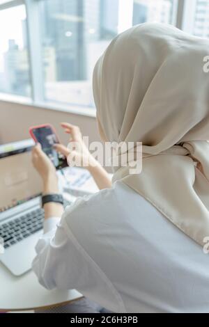 muslim women doing work with her gadget Stock Photo