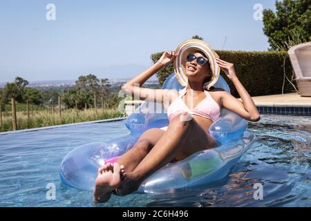 Woman floating on inflatable ring in the pool Stock Photo
