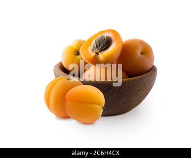 Various fresh summer fruits. Apricots in a wooden bowl. Ripe apricots with copy space for text. Fruit on white background. Apricots with leaves isolat Stock Photo