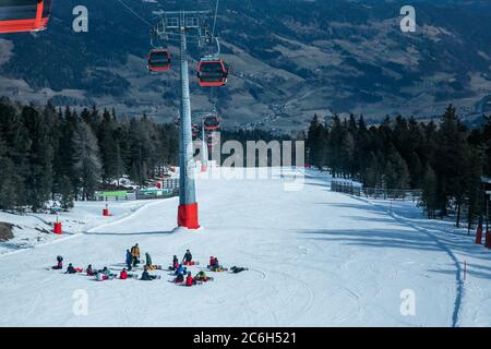 Lots of skiers and snowboarders have a rest on a slope at ski resort Stock Photo