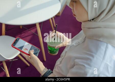 muslim women doing work with her gadget Stock Photo