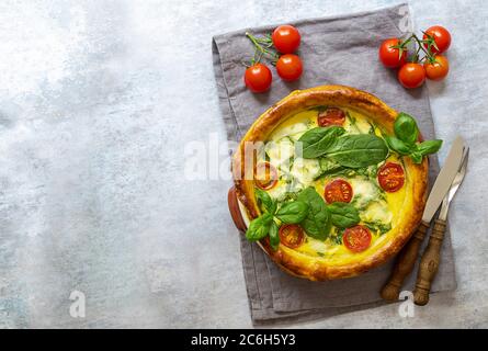 Open pie or french quiche with spinach, feta, and mozzarella cheese, and tomatoes cherry. Vegetarian meal. Stock Photo