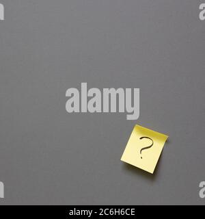 Question mark on sticky memo paper on gray background. Solution concept Stock Photo