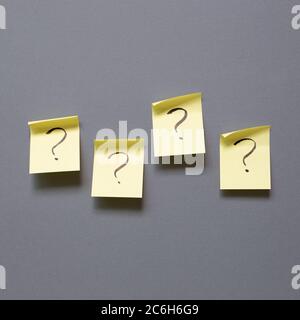 Question mark on sticky memo paper on gray background. Solution concept Stock Photo