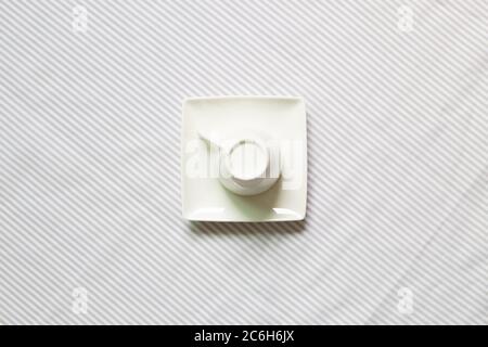 White coffee cup on gray stripe pattern fabric background. top view Stock Photo
